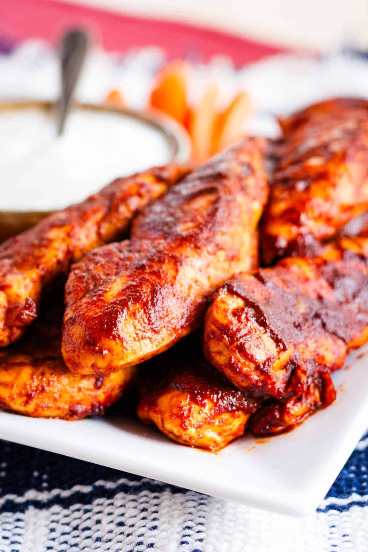 A white plate is piled with buffalo chicken tenders.