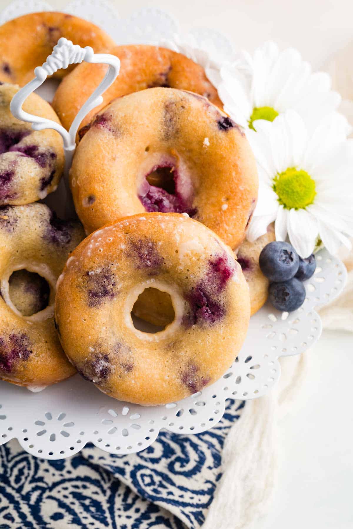 Gluten free blueberry donuts are served on a doiley.