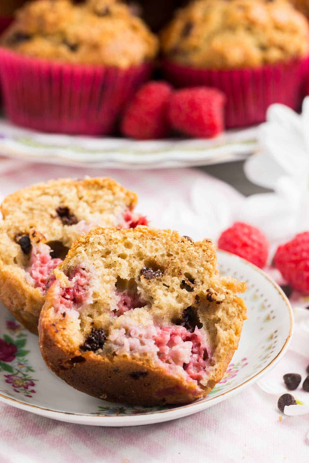 A cut gluten free raspberry muffin on a small plate.