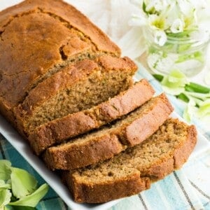 A sliced loaf of gluten free zucchini bread on a white rectangular plate.