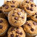 Chocolate chip zucchini muffins with chocolate chips piled in a bowl with text overlay that says "Gluten Free Zucchini Muffins".