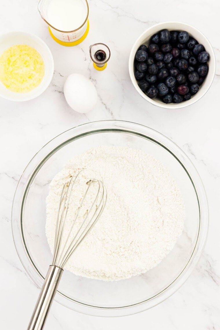 The dry ingredients for blueberry donuts are whisked together.