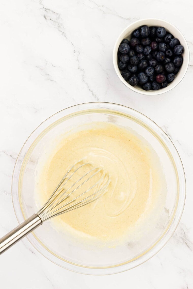 A whisk blends the donut batter until smooth.