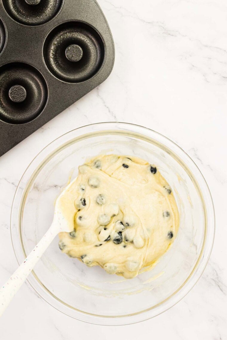 The blueberries are folded into the donut batter.