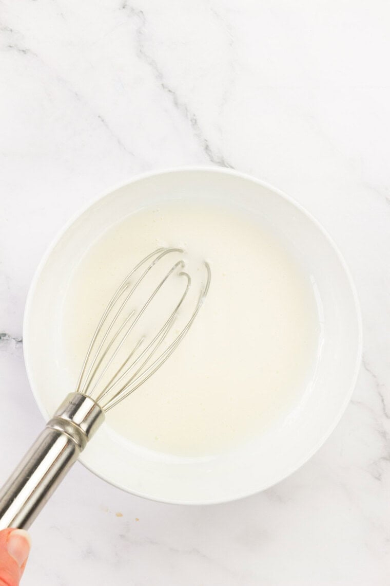 A whisk is used to blend the glaze until smooth.