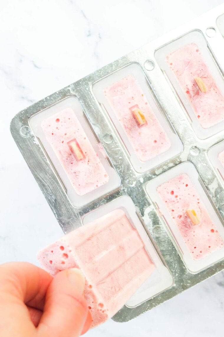 One of the frozen popsicles being removed from the mold.