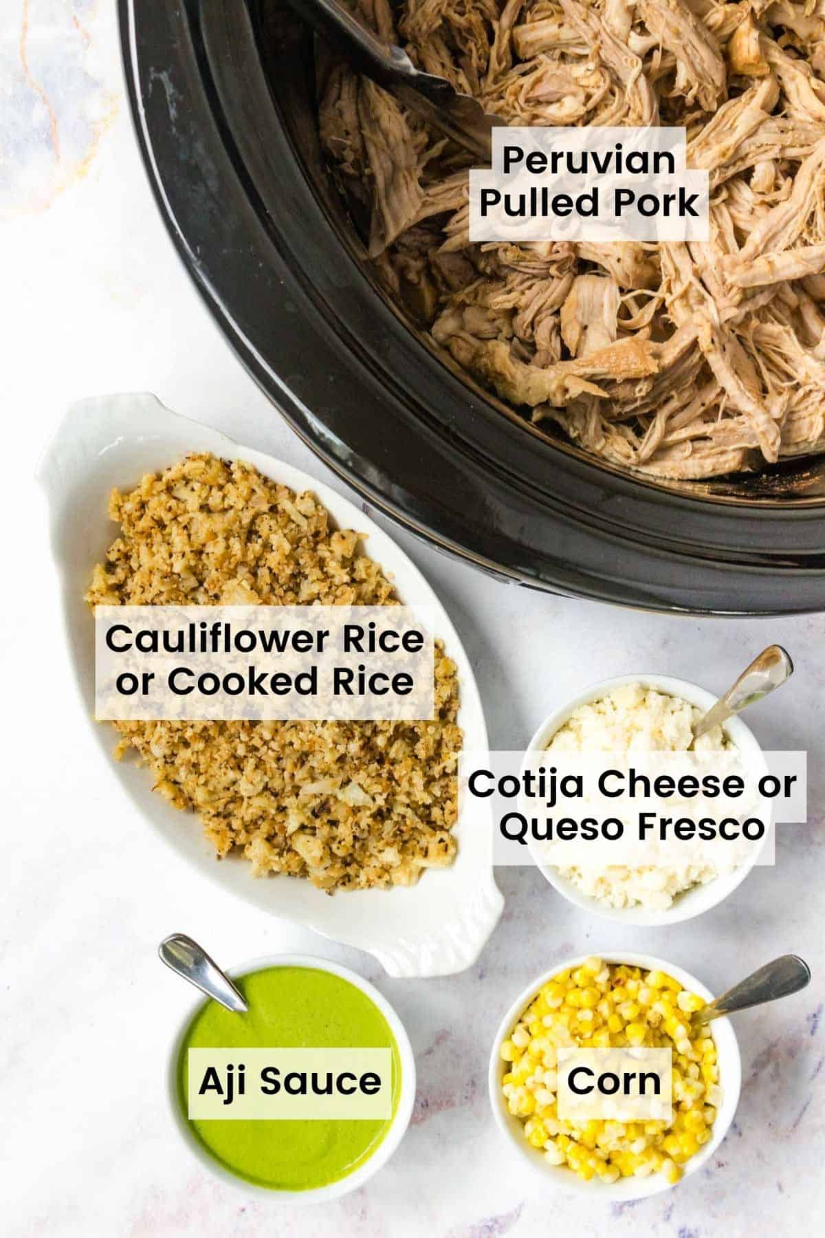 A bowl of cauliflower rice and rice bowl toppings next to a crockpot of pulled pork with each item labeled.