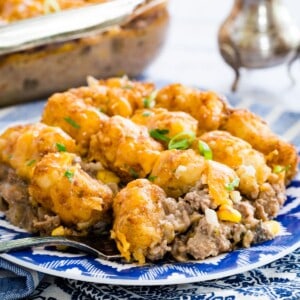 A serving of tater to cowboy casserole on a blue and white plate.