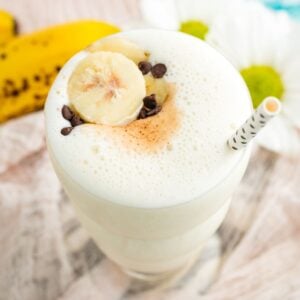 A birdseye view of a banana smoothie with banana slices and mini chocolate chips on top.