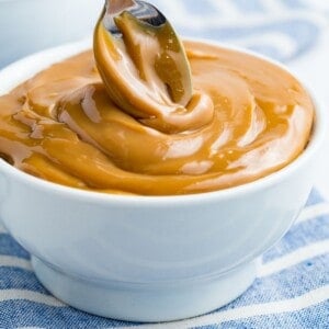 A spoon swirls into a bowl of homemade dulce de leche.