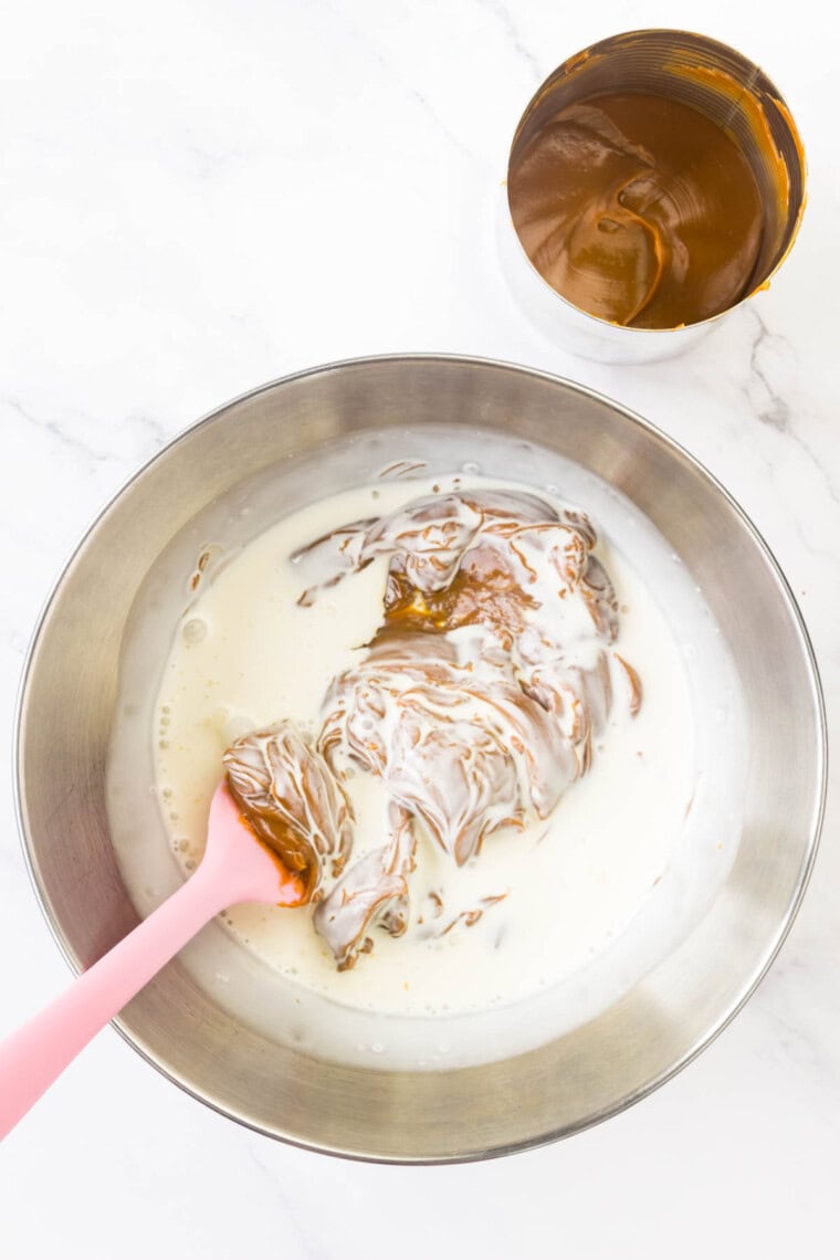 Dulce de leche is heated and stirred.
