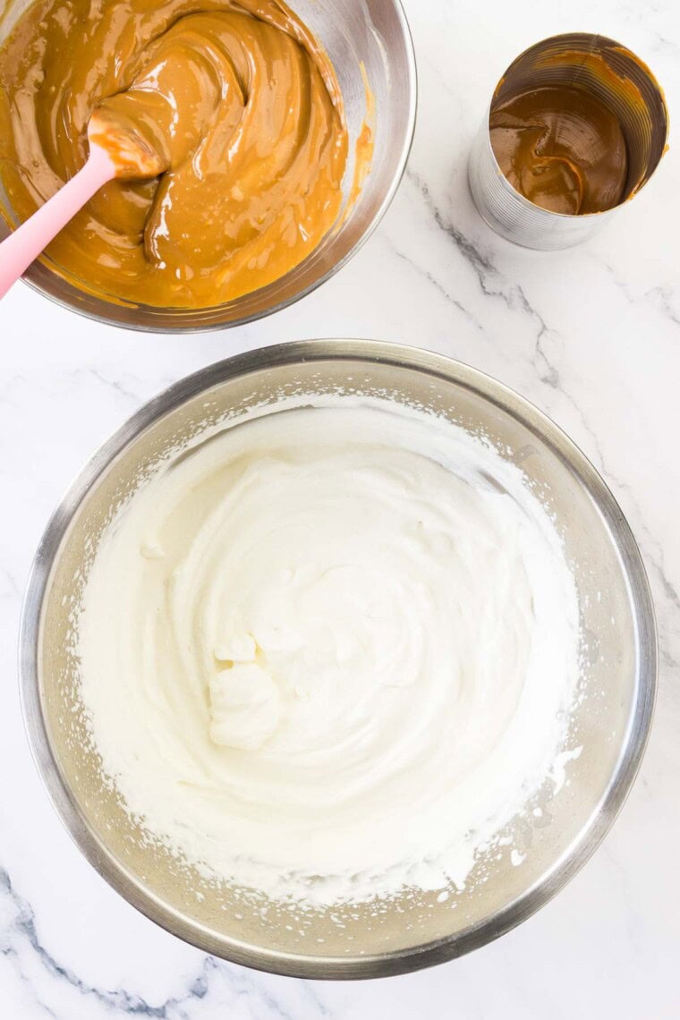 The whipped cream ice cream base in a bowl with dulce de leche next to it in a separate bowl.
