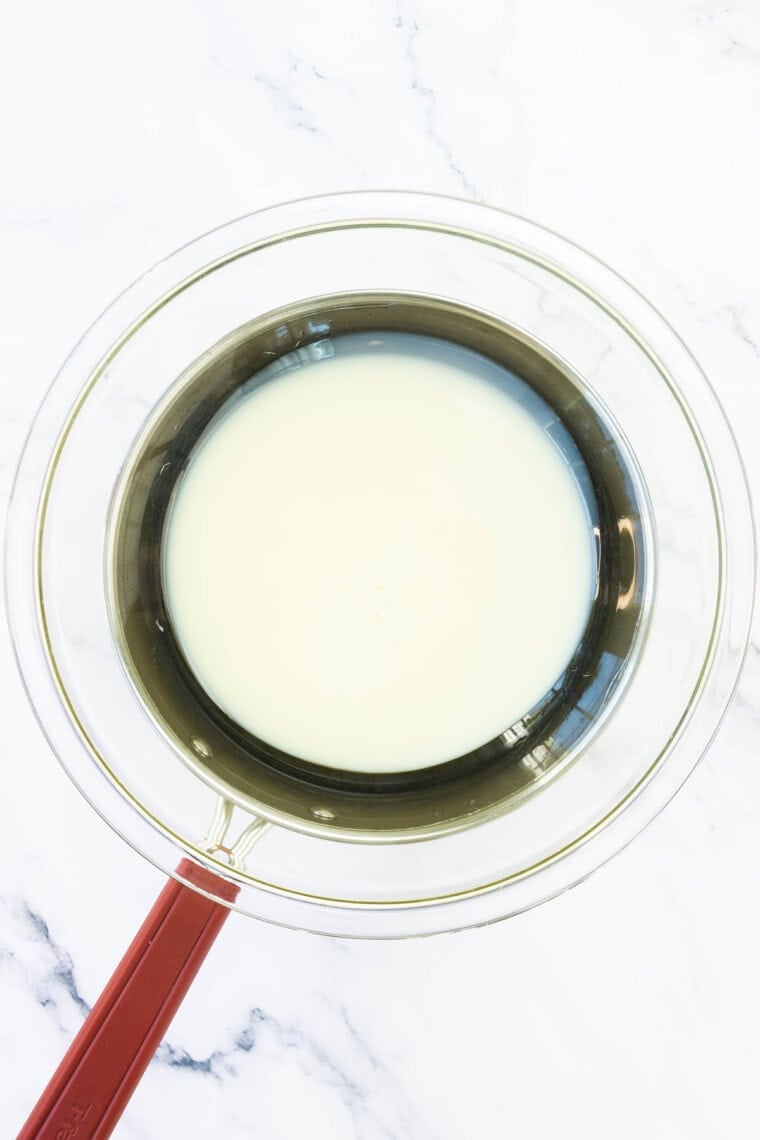 Condensed milk is placed in a pot to make dulce de leche.