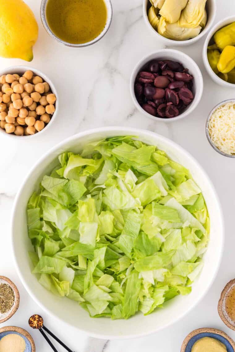 Lettuce is added to a bowl.