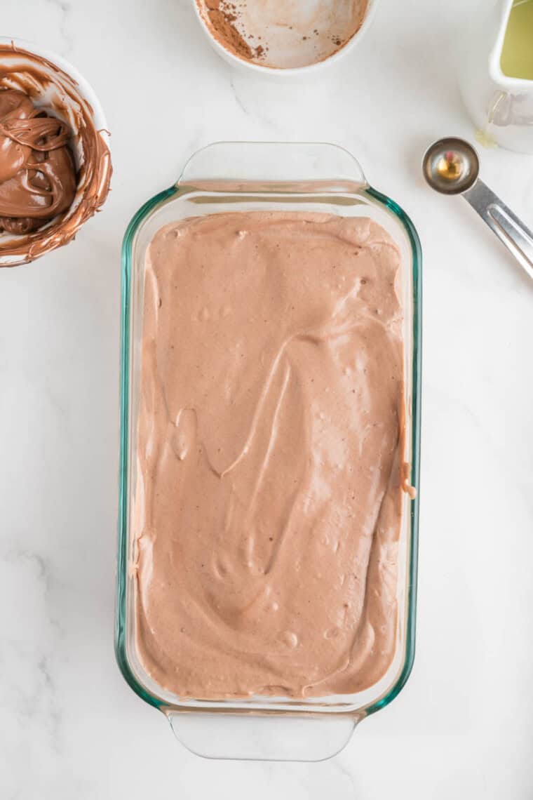 Nutella ice cream is transferred to a loaf pan.