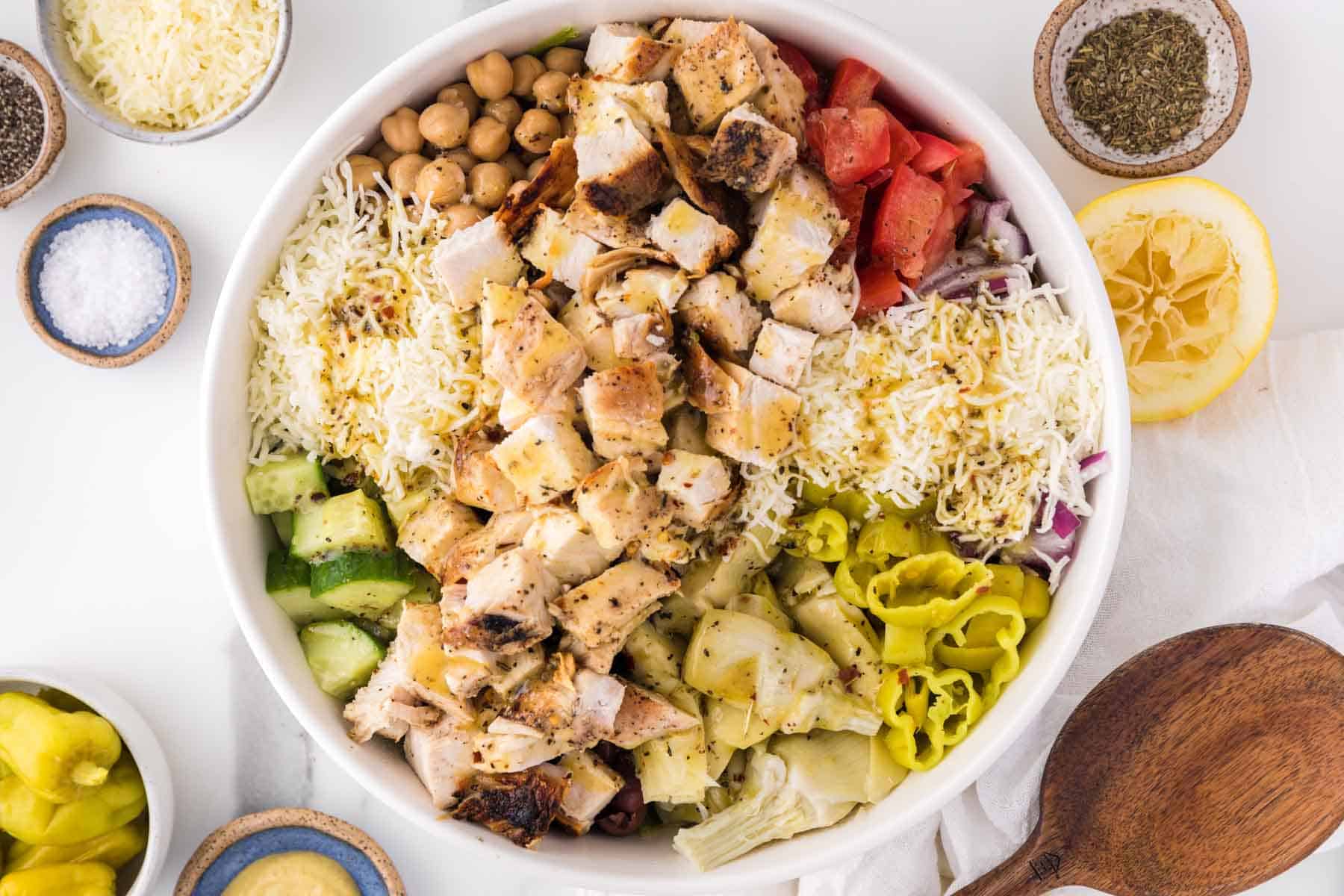 Chicken, chickpeas, vegetables, cheese, and more on top of an Italian chopped salad.