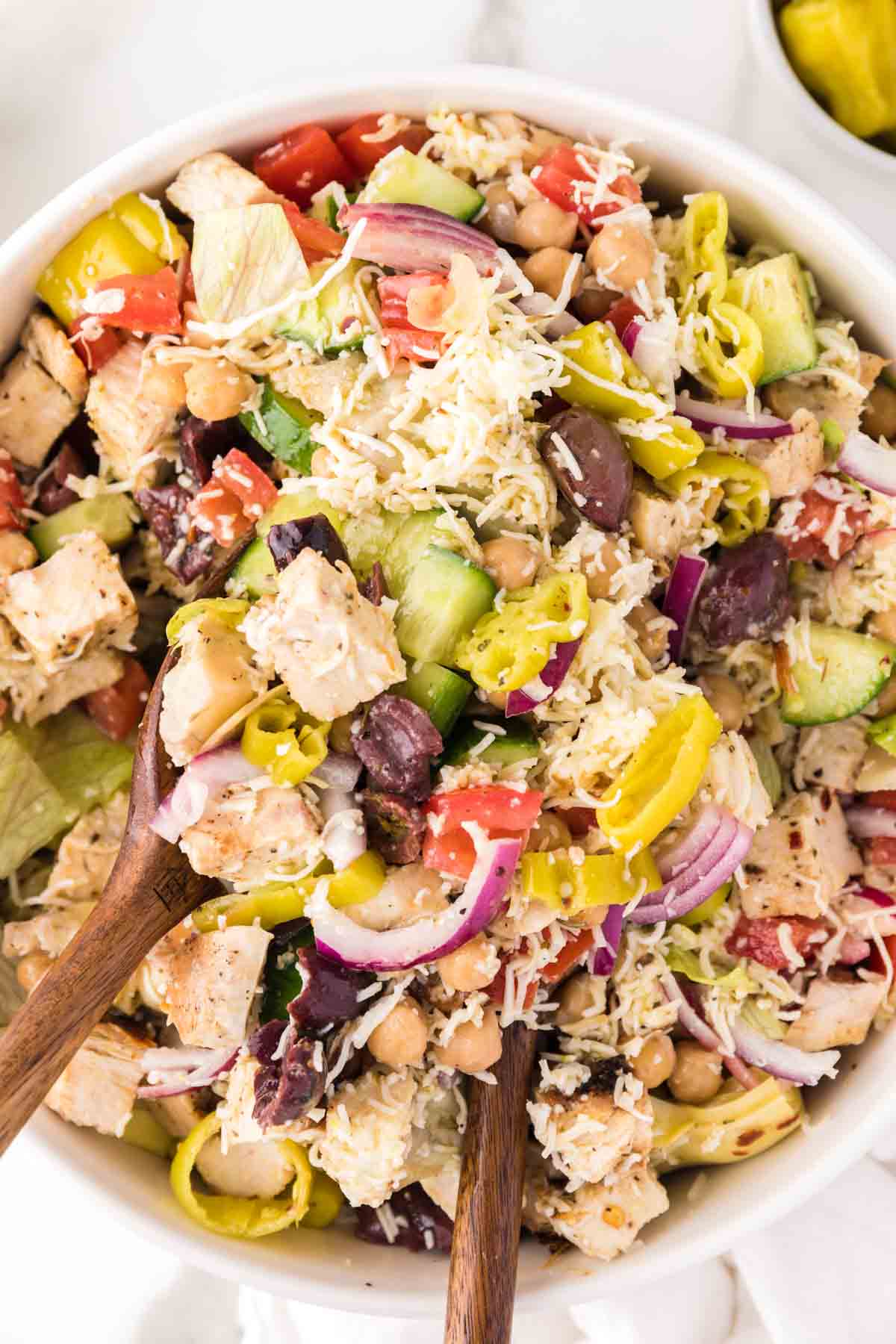 Chicken, chickpeas, vegetables, cheese, and more on top of an Italian chopped salad.