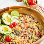 Avocados and lime slices top a bowl of Mexican quinoa salad.