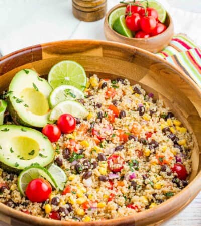 Avocados and lime slices top a bowl of Mexican quinoa salad.