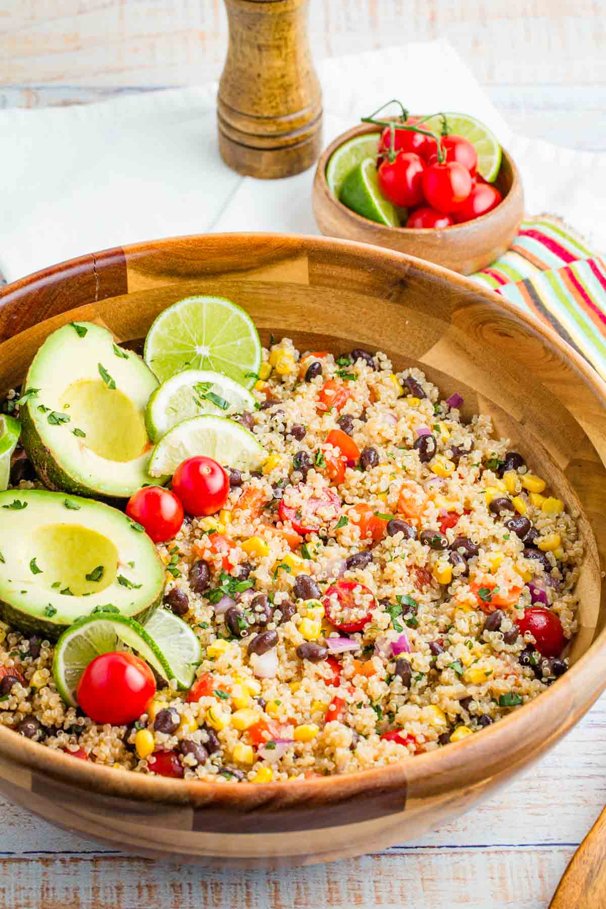 Avocados and lime slices top a bowl of Mexican quinoa salad.