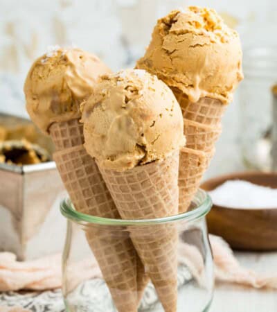 A glass container holds three cones of dulce de leche ice cream.
