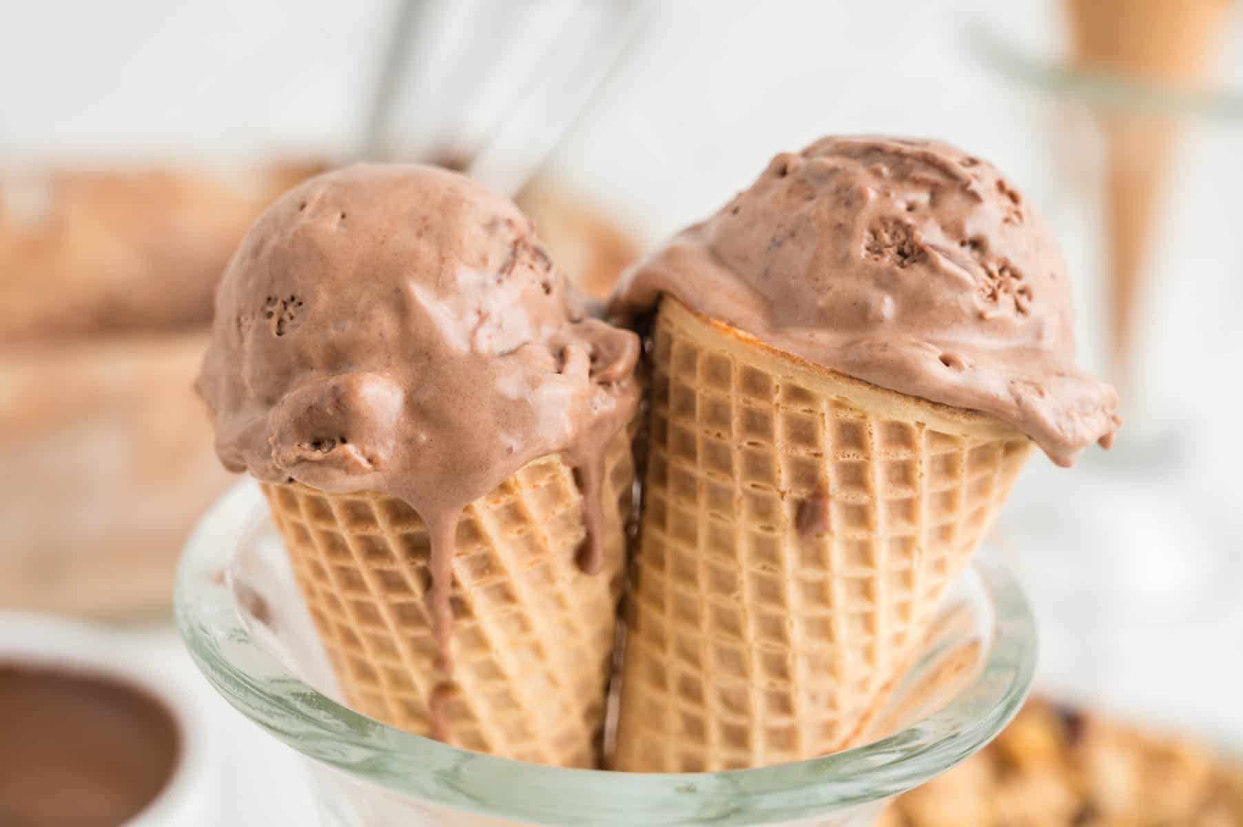 Two cones of nutella ice cream are served in a glass bowl.