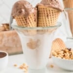 Two slightly melted chocolate ice cream cones in a frosty glass with text overlay that says "No-Churn Nutella Ice Cream".