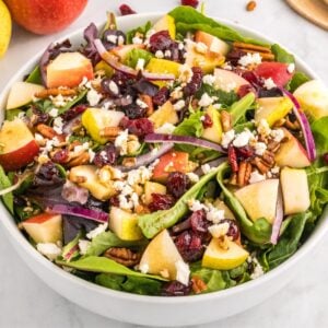 A big bowl of harvest salad with serving spoons next to it.