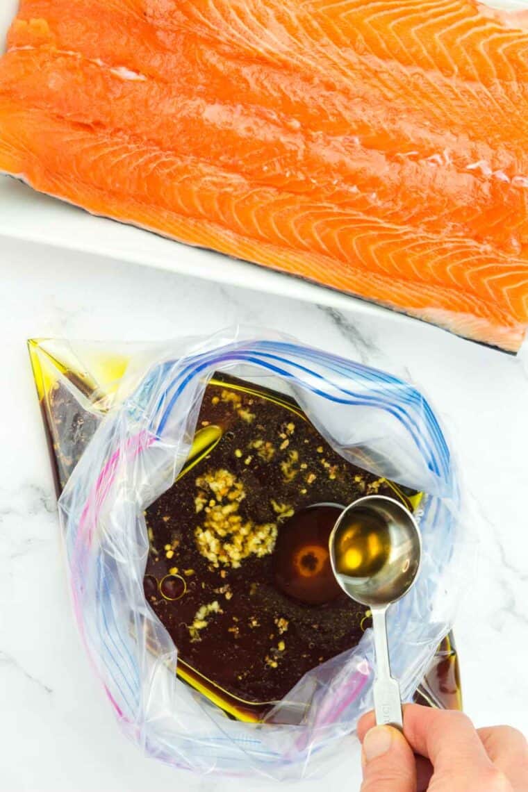 Pouring maple syrup into a plastic bag with the rest of the salmon marinade ingredients.