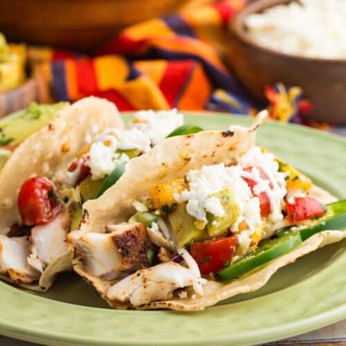 Two tilapia fish tacos on a plate.