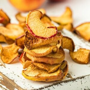 A stack of apple chips on a wooden board.