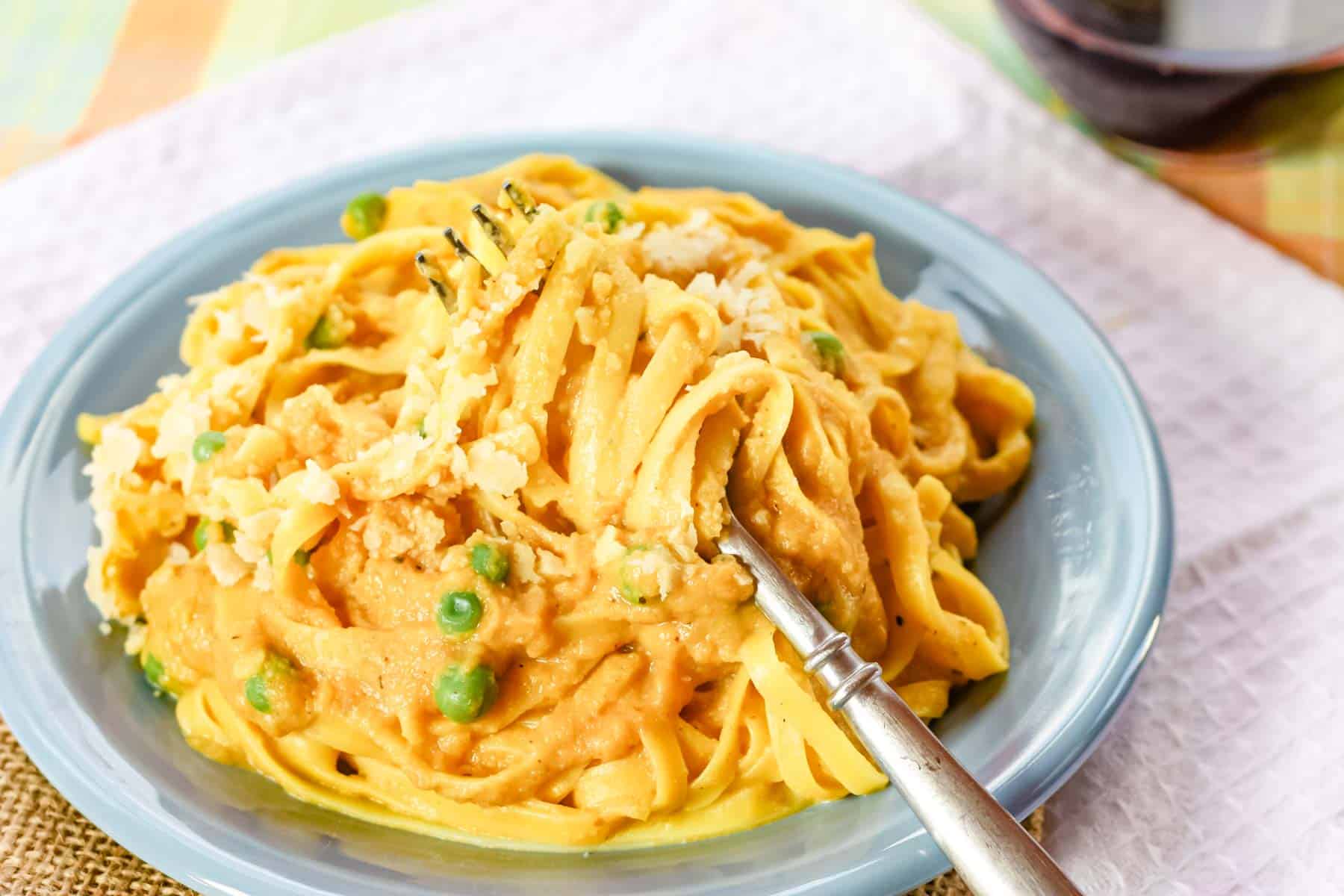 A plate of pumpkin alfredo with a fork.