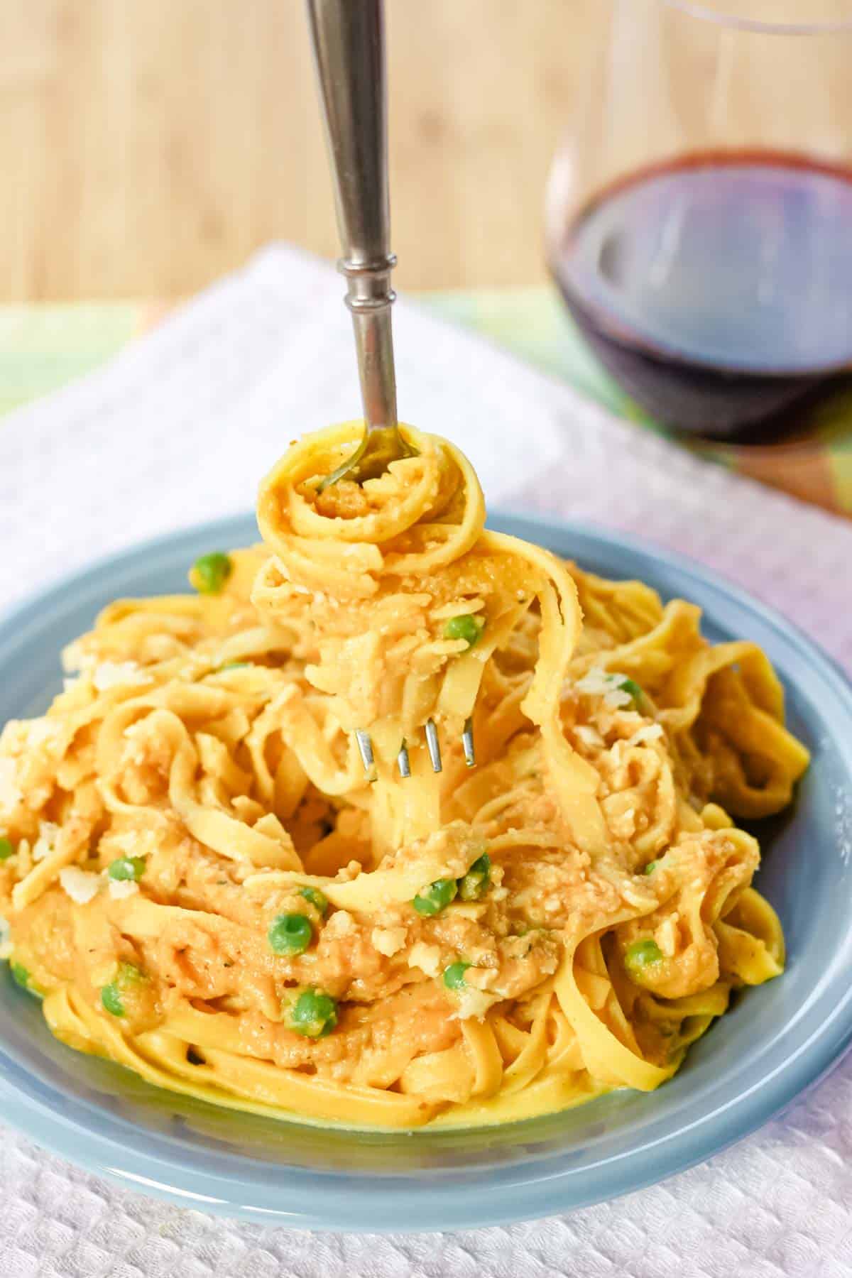 A fork twirls pumpkin fettuccine alfredo.