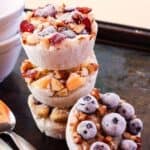 Frozen rounds of cooked oatmeal topped with fruit and nuts with text overlay that says "Frozen Oatmeal Cups".