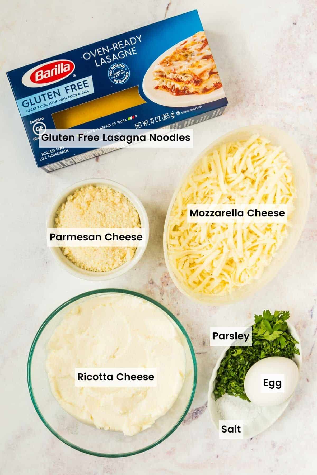 Barilla no boil gluten free lasagna sheets, plus bowls of mozzarella, parmesan, and the ingredients for the ricotta filling with text labels.