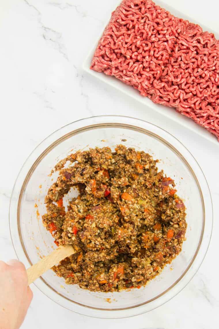 A spoon stirs meatloaf mix.