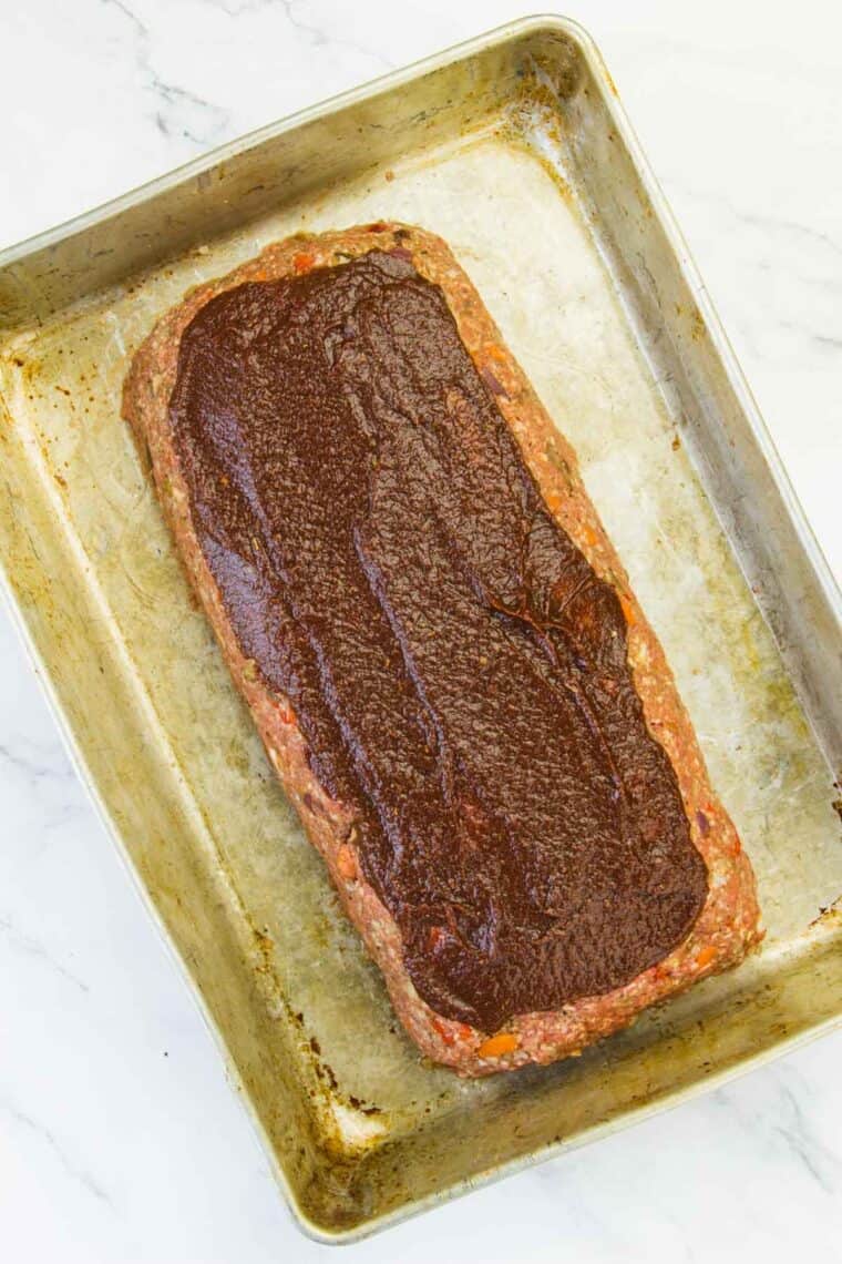 Meatloaf topped with balsamic ketchup in a baking pan.