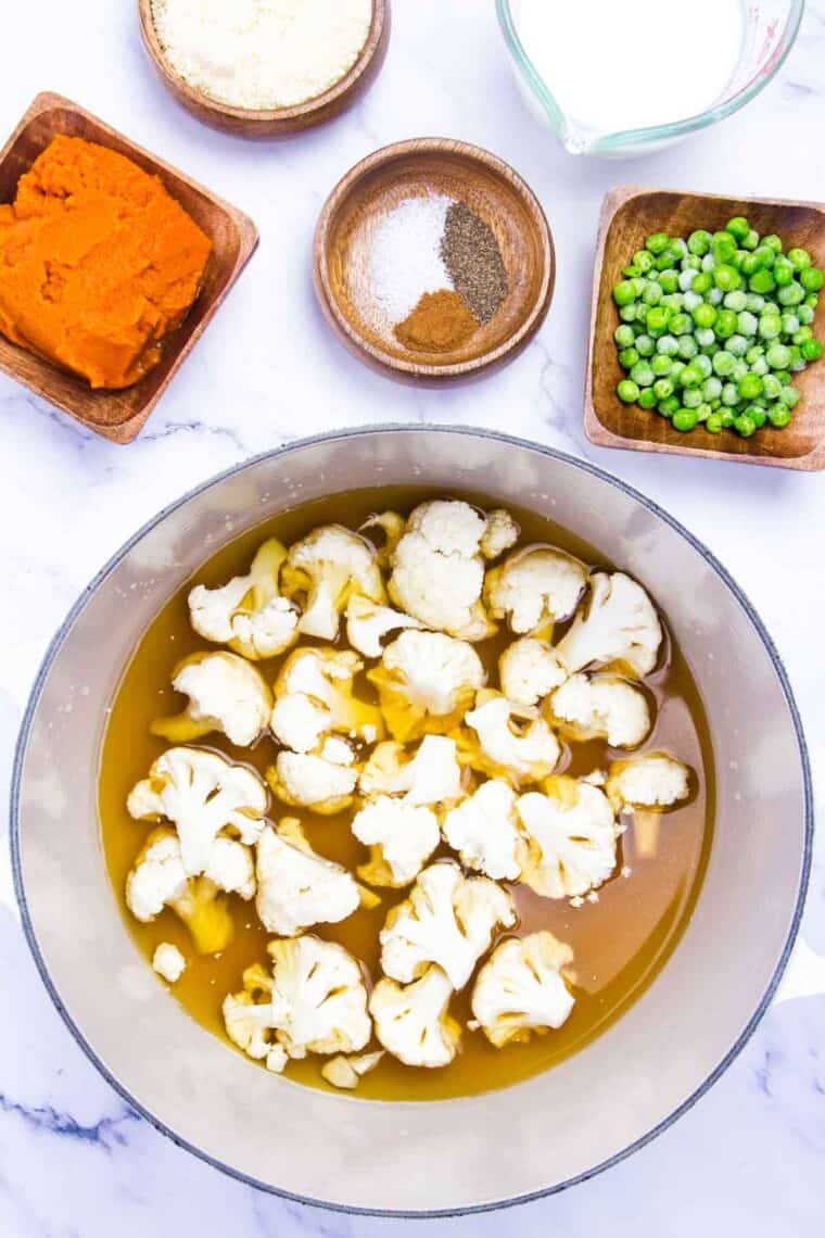 Cauliflower and pumpkin puree are added to a pot.