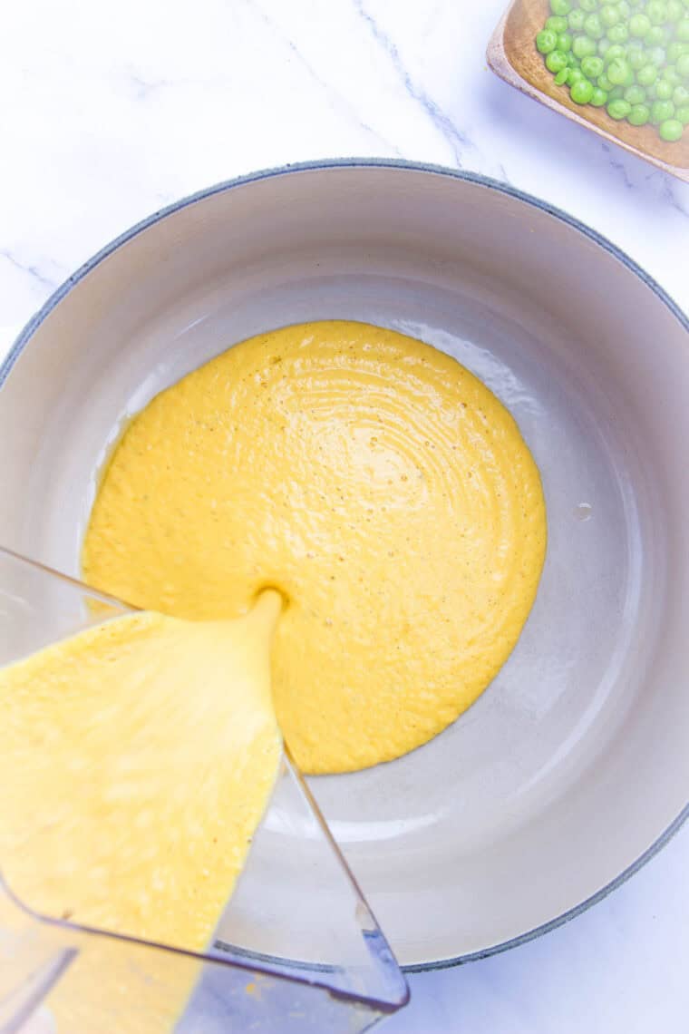 Pumpkin alfredo sauce is poured into a bowl.