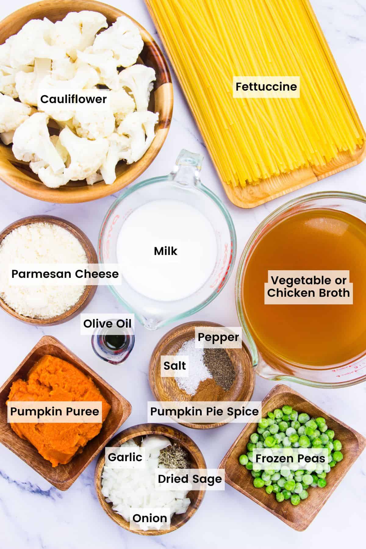 Labeled ingredients for pumpkin alfredo: pumpkin puree, broth, cauliflower, pumpkin pie spice, peas, olive oil, salt and pepper, parmesan.