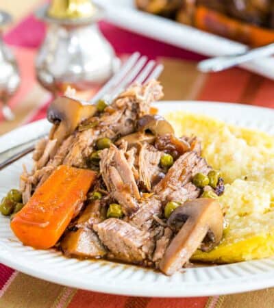 A plate of slow cooker pot roast with carrots and mashed potatoes.