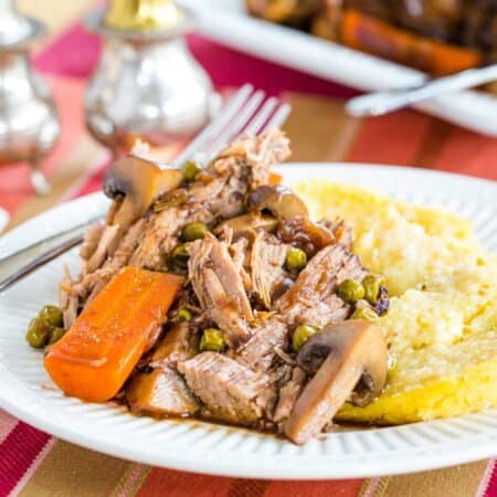 A plate of slow cooker pot roast with carrots and mashed potatoes.