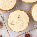 Cream cheese icing sprinkled with cinnamon on pumpkin cookies.