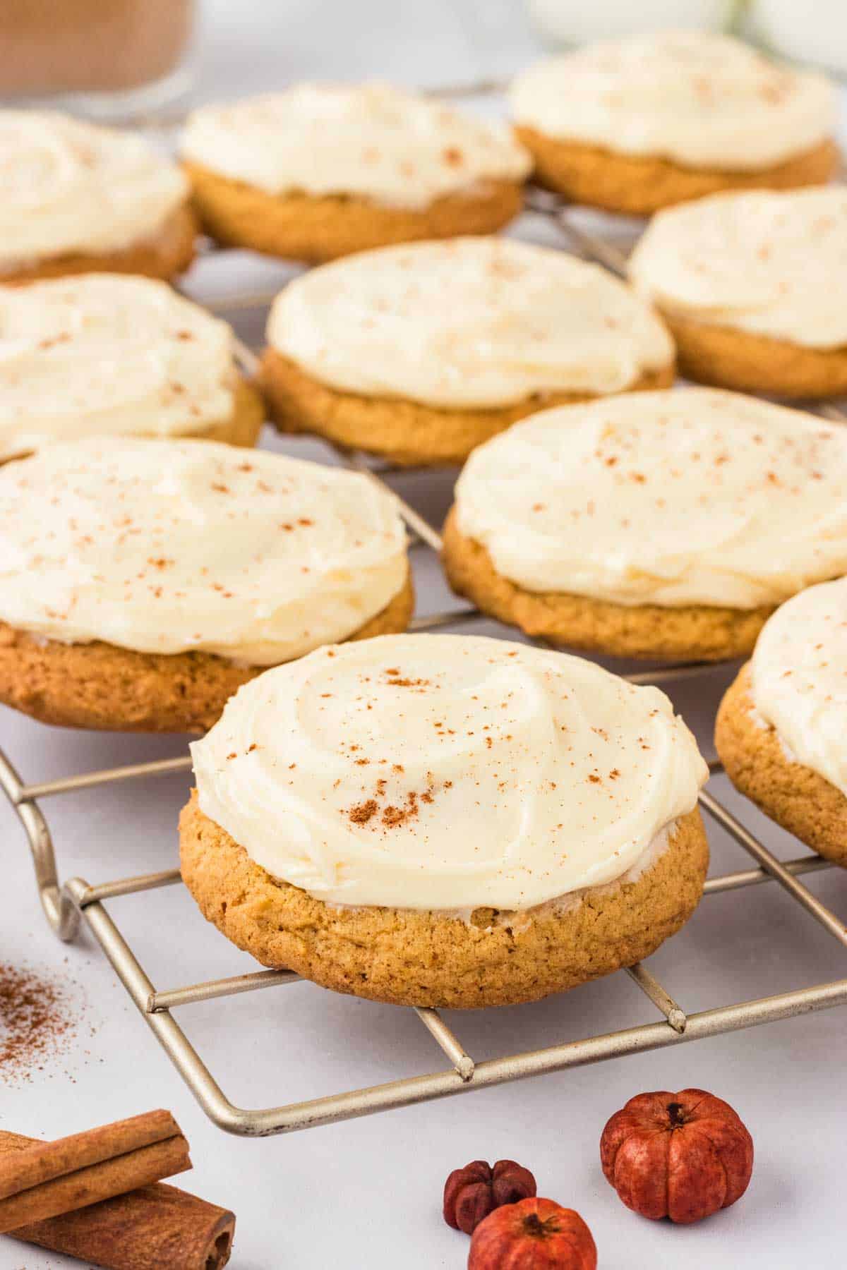 A wire rack holds frosted pumpkin cookies.