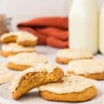 One frosted cookie with a bite taken out leaning on top of another one with text overlay that says "Gluten Free Pumpkin Cookies".