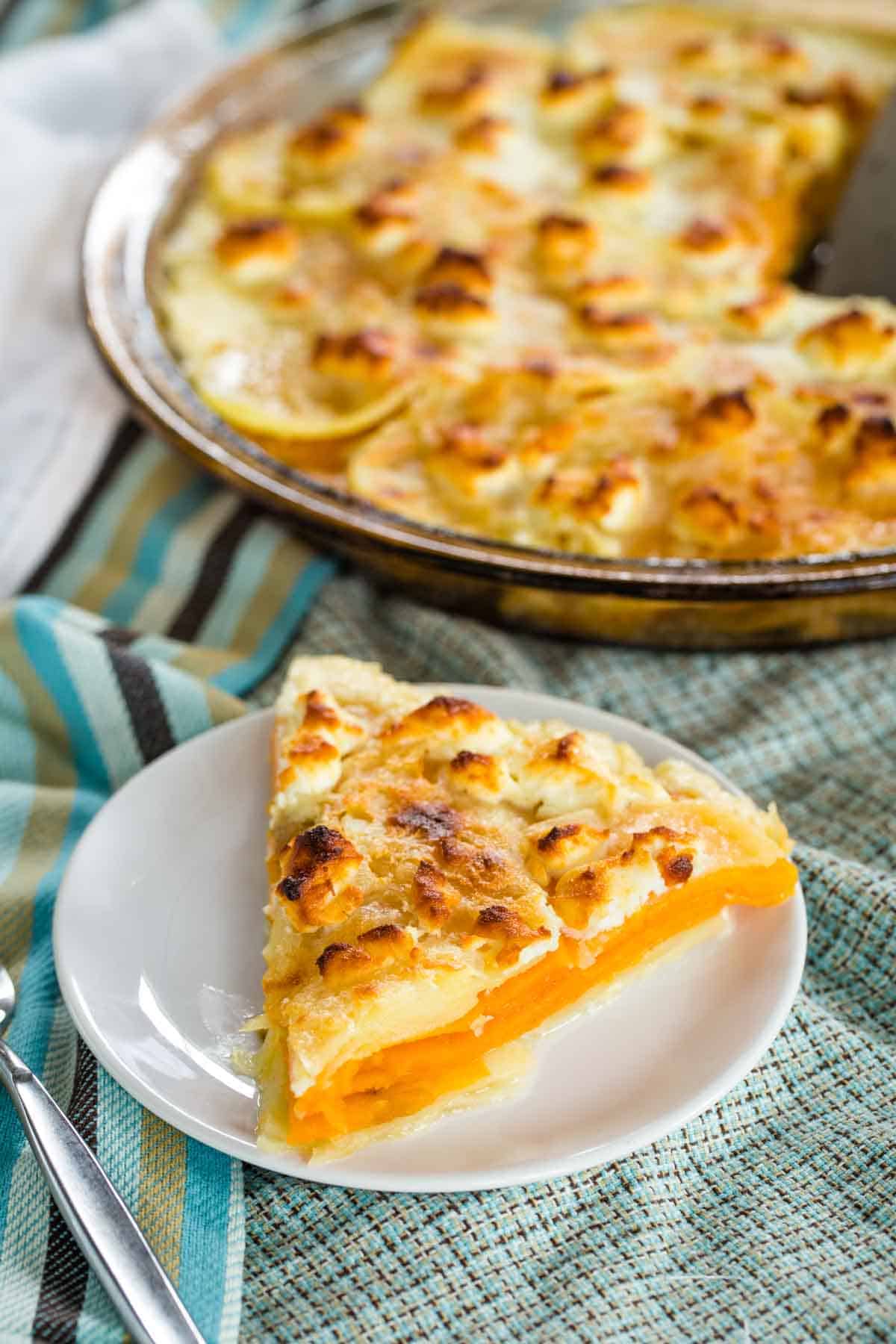 A round dish full of goat cheese sweet potato gratin and a piece on a plate.