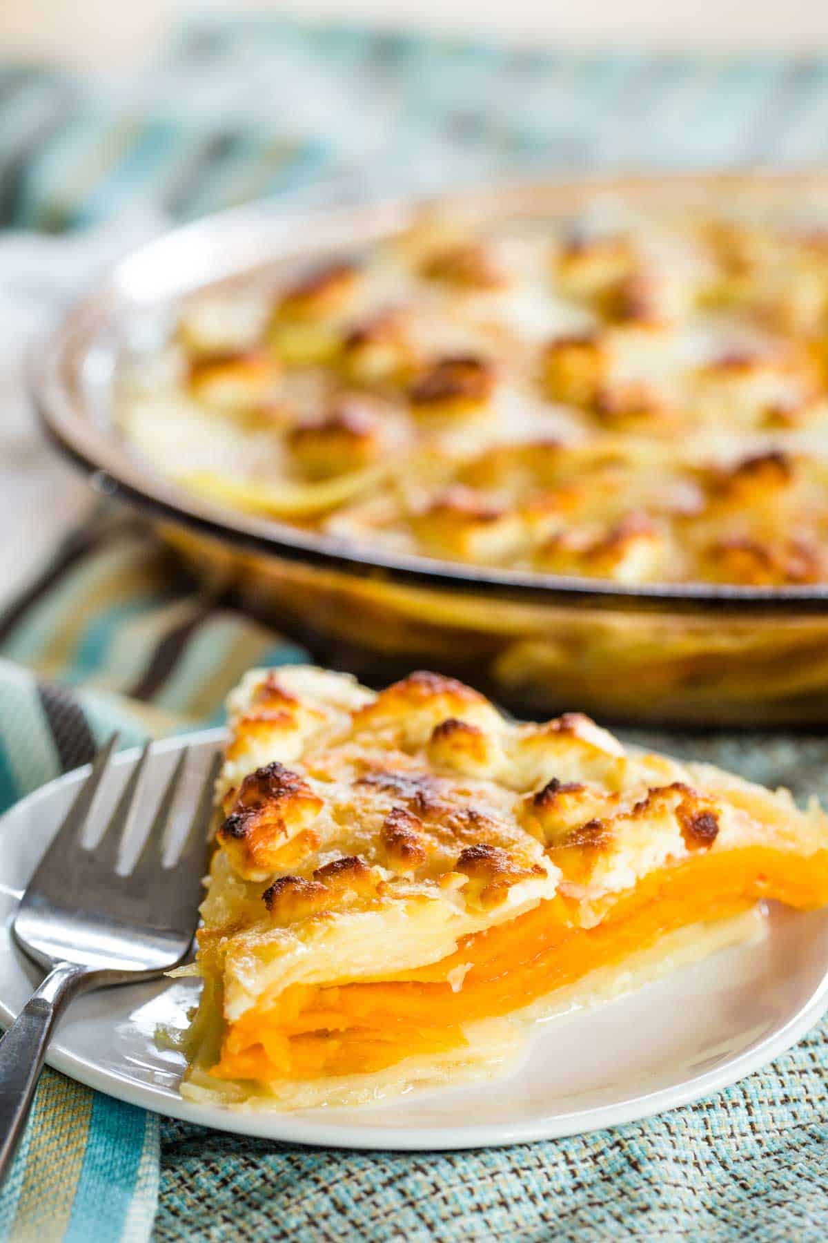 A piece of goat cheese sweet potato gratin on a white plate.