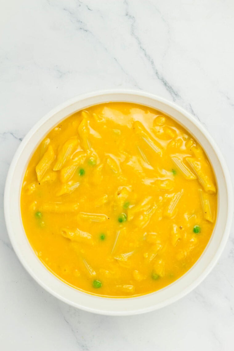 Unbaked macaroni and cheese in a casserole dish.