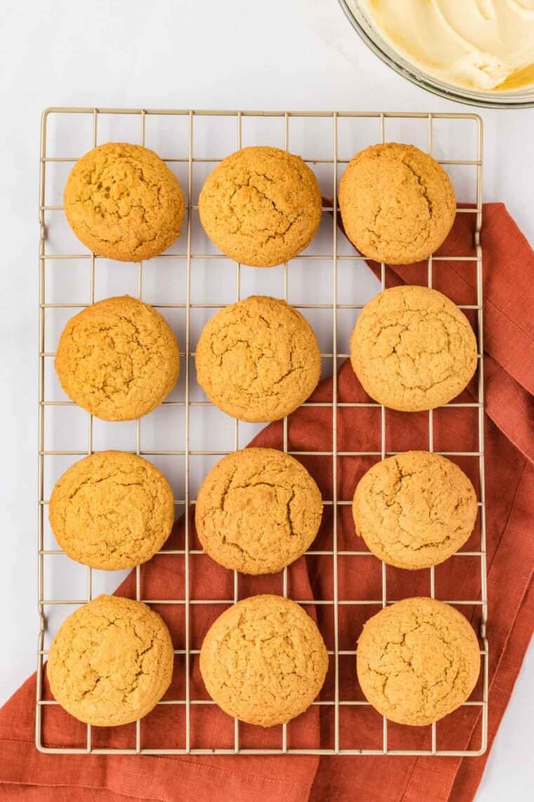 Pumpkin cookies cool on a rack.