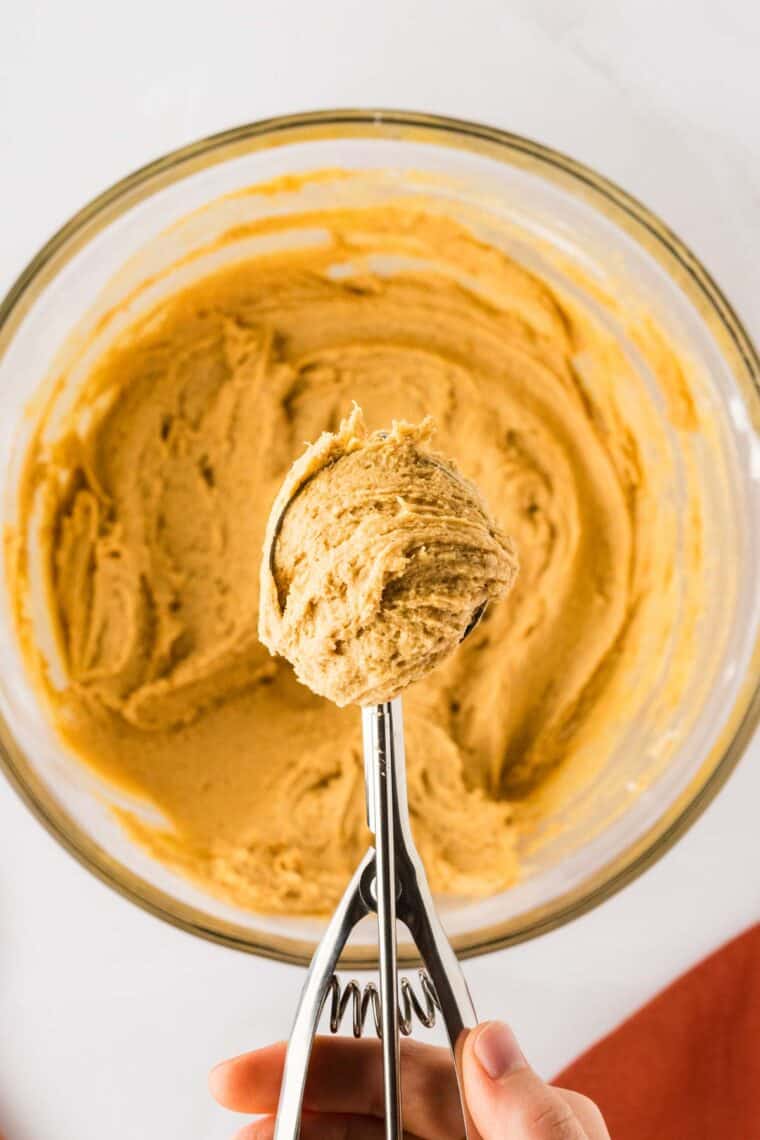A cookie scoop with pumpkin cookies.